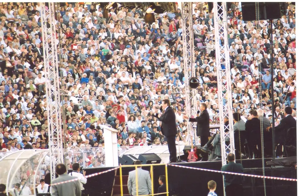 Reinhard Bonnke predicând pe scenă, cu tribunele Stadionului Dan Păltinișanu pline, Timișoara, 2006